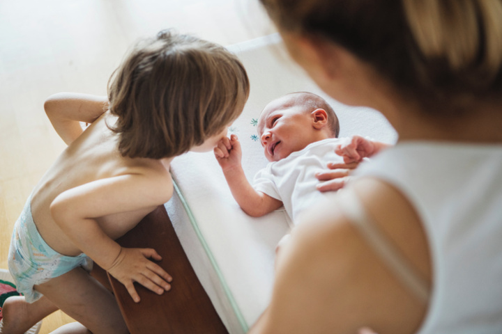 A mother changing a baby's nappy to prevent it leaking overnight.