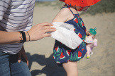 A parent wiping a toddler's arm with a WaterWipes XL Bathing Wipe
