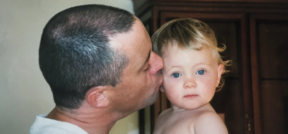 Papa küsst sein Baby, liebevoll und fürsorglich.