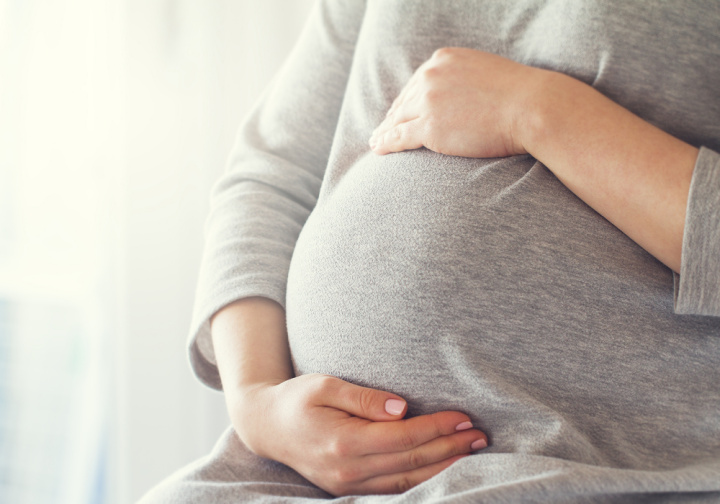 A pregnant woman holding her belly