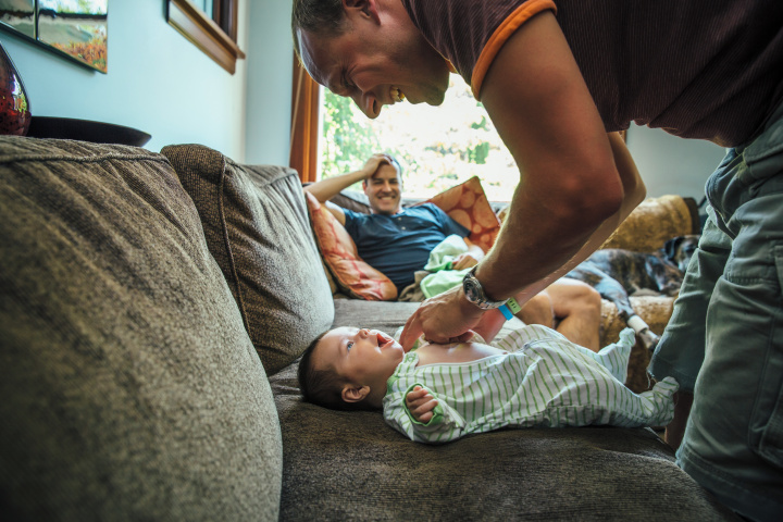 dad lying down beside mum and a newborn baby