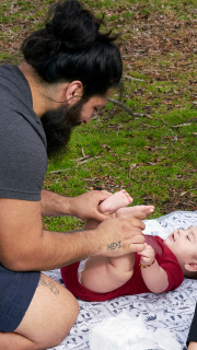 A father changes his baby's nappy.