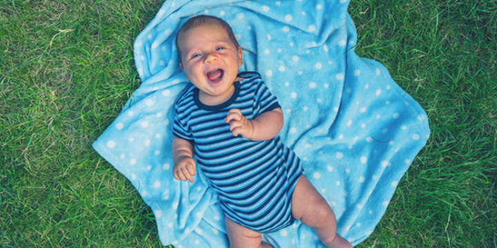 Baby lying on blanket outside