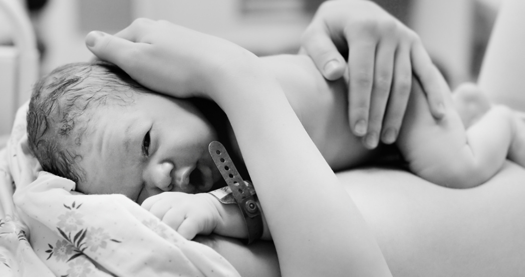 Um bebê recém-nascido descansando no peito de sua mãe