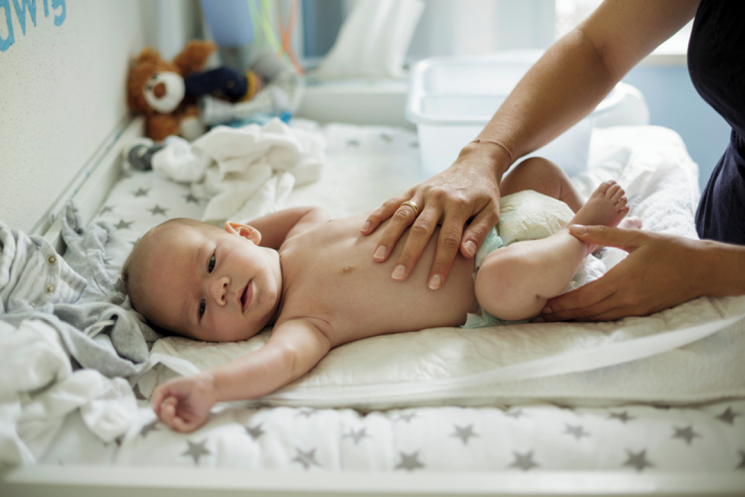 a mother changing her baby’s nappy.