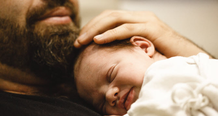 A dad holding his newborn baby