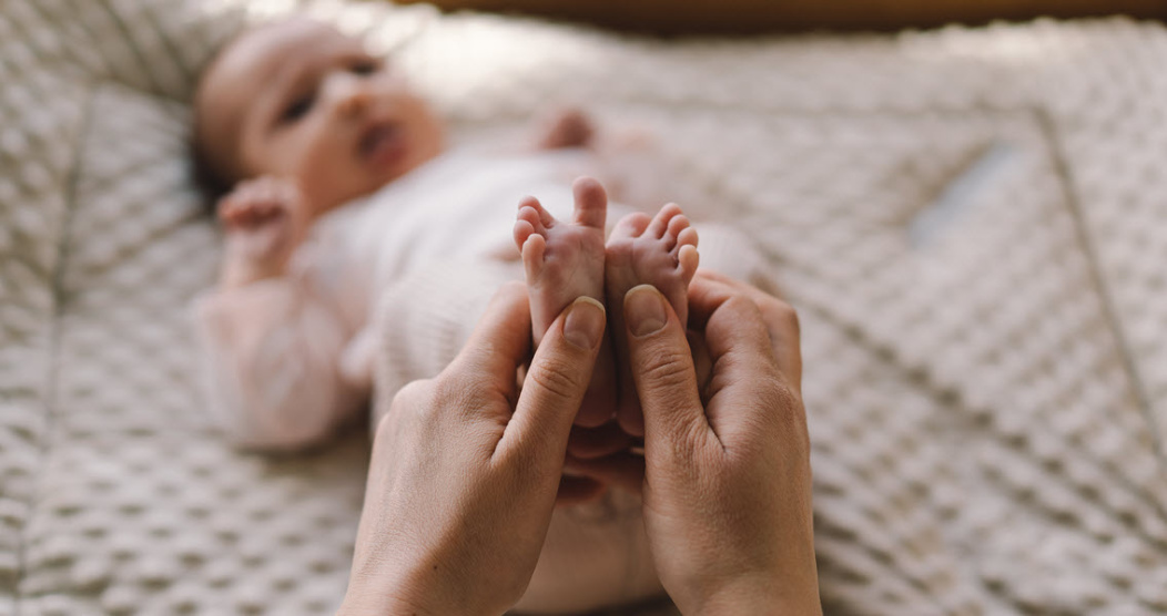 Parent holding their newborn baby's feet