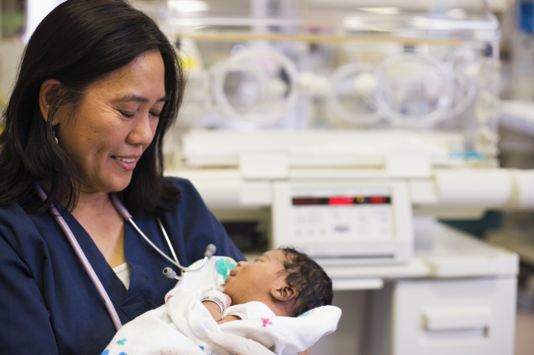 nurse holding baby in NICU