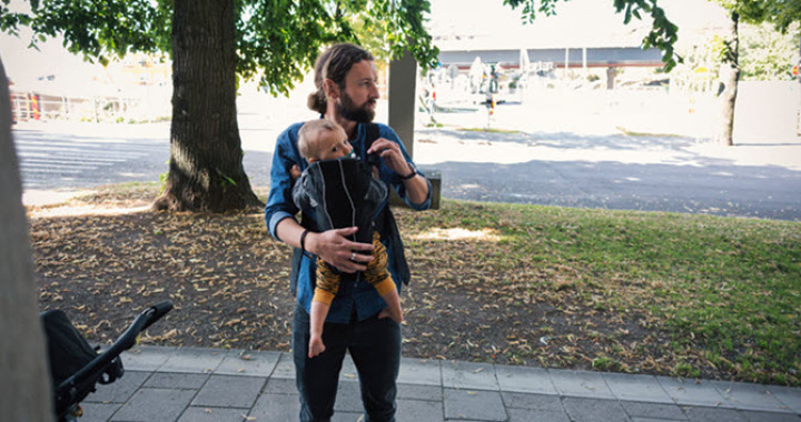 Dad out and about with his baby in a sling