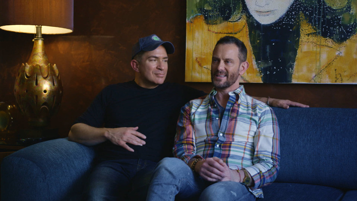 Two fathers sitting on a sofa.