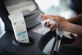 A runner using WaterWipes On The Go after being on a treadmill
