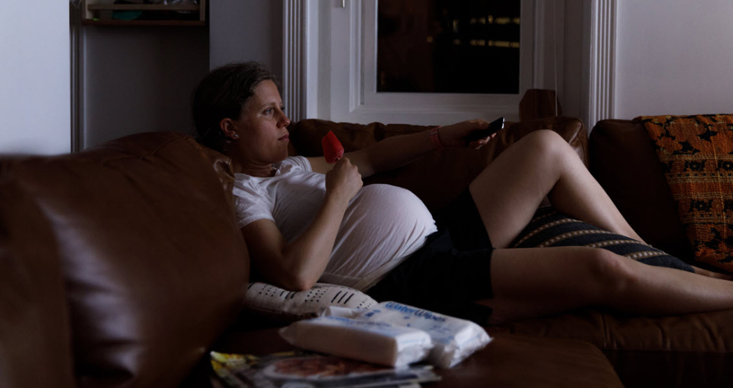 A pregnant woman relaxing on sofa