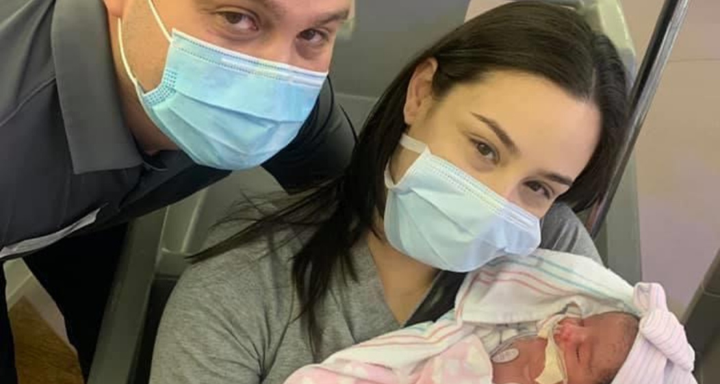 Two parents in the NICU holding their baby