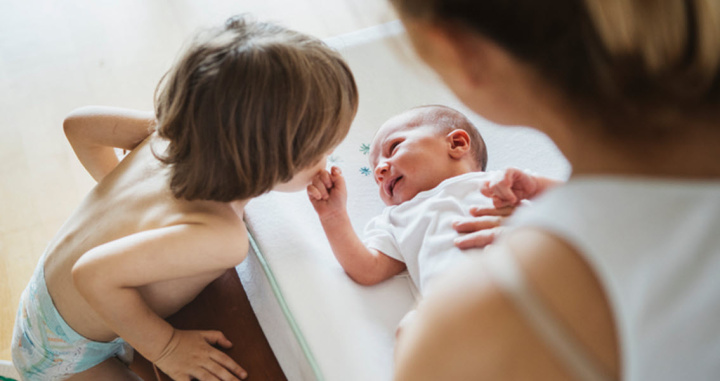 newborn lying on a nappy changing table