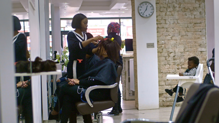 a woman receiving a haircut from another woman