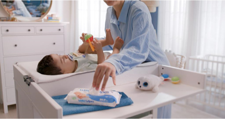 A mother changing her baby's diaper