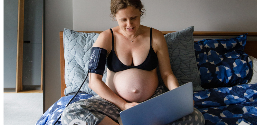 embarazada en la cama con un computador.
